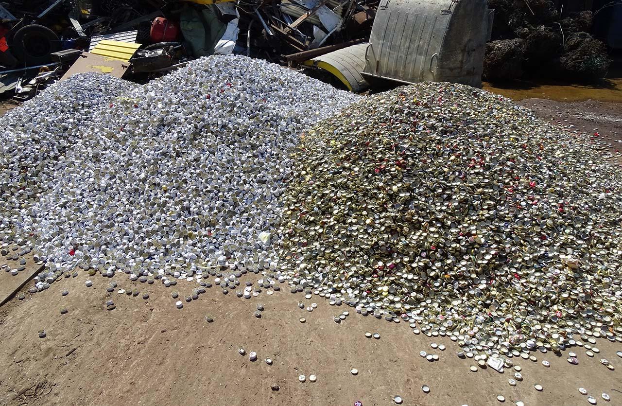 Haufen Kronkorken und Metalldeckel auf Wertstoffhof 